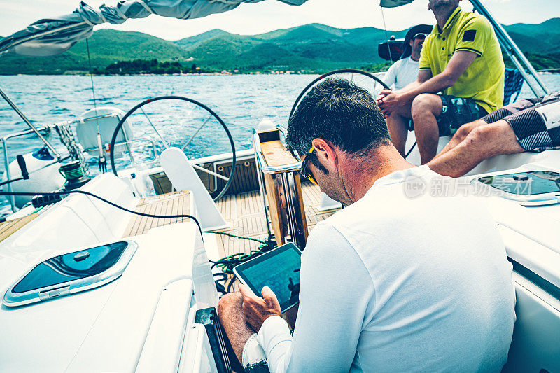 在帆船上使用数字平板电脑航行的人