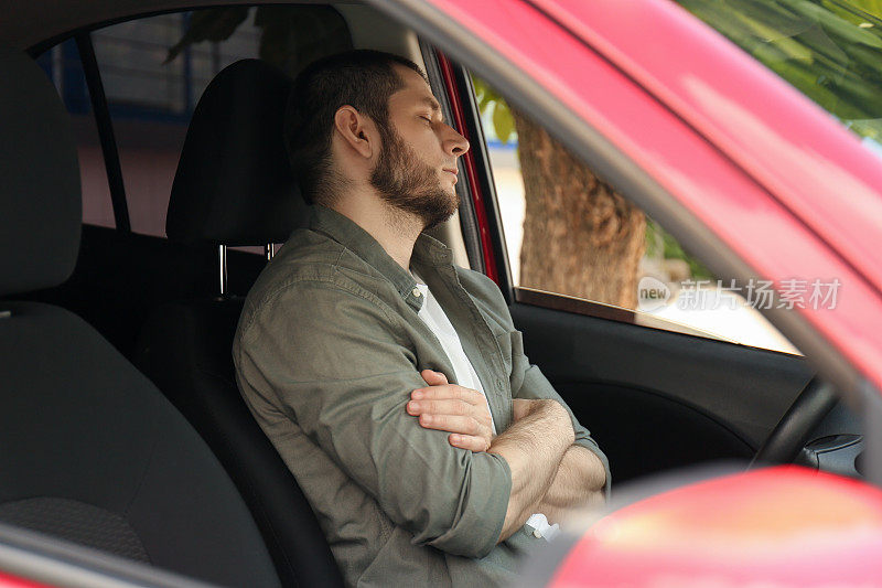 一个疲惫的人睡在他的现代车里