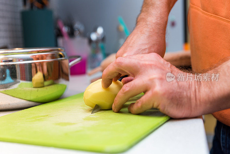 近距离男子手在厨房切土豆片