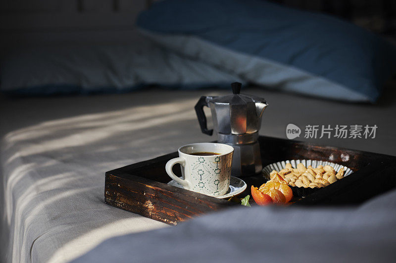 放松时间:咖啡、橘子和坚果放在床上