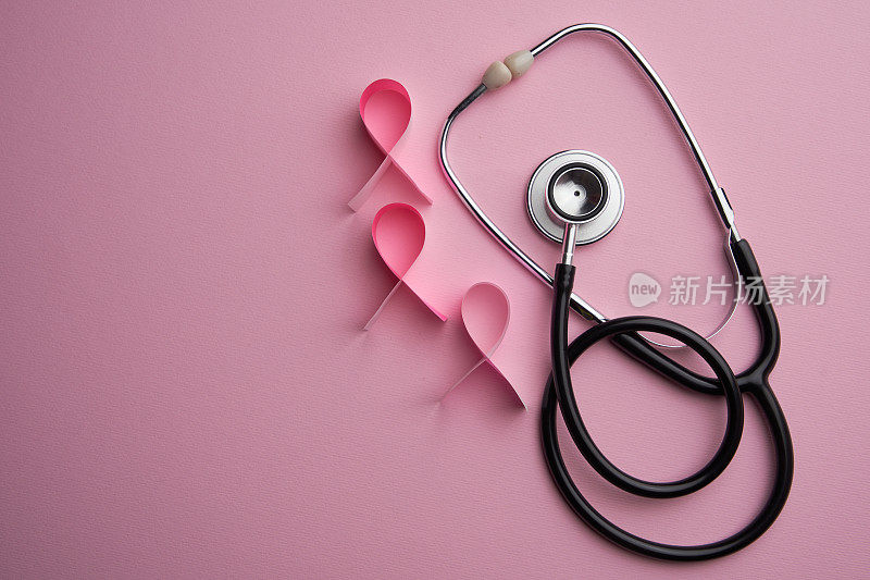 粉红丝带乳癌意识符号和听诊器与粉红背景