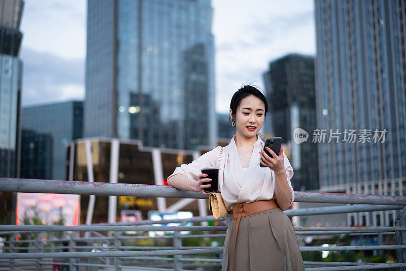 亚洲商业女性站在城市街头，写字楼背景，成功、自信的女性理念