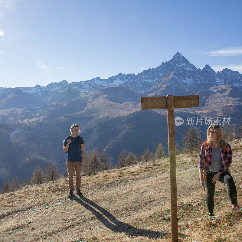 年轻的男女在雪山下徒步旅行