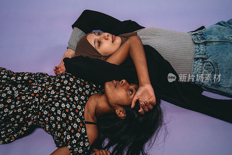 两个朋友一起躺在紫色的背景下