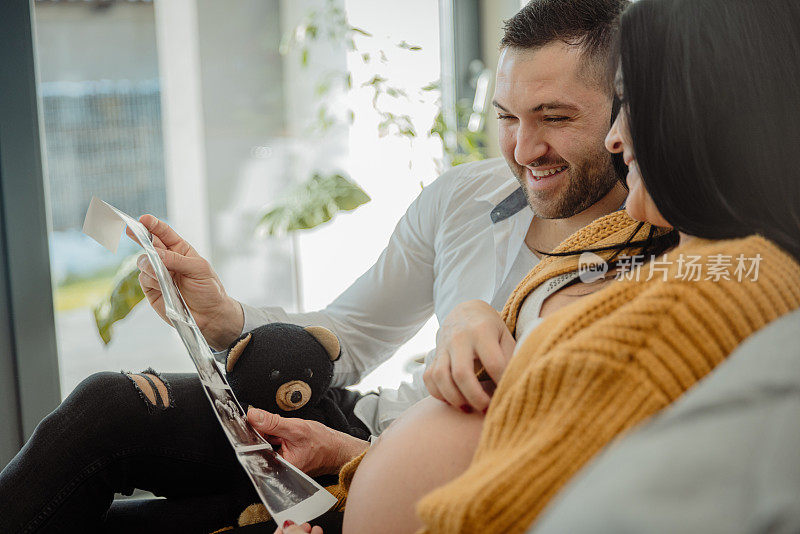 快乐的夫妇看着宝宝的超声波扫描
