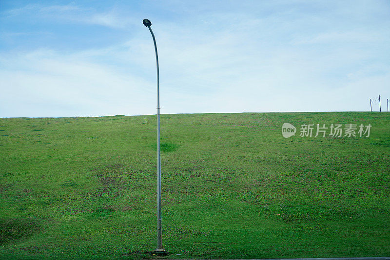 绿草如茵的小山丘上的路灯