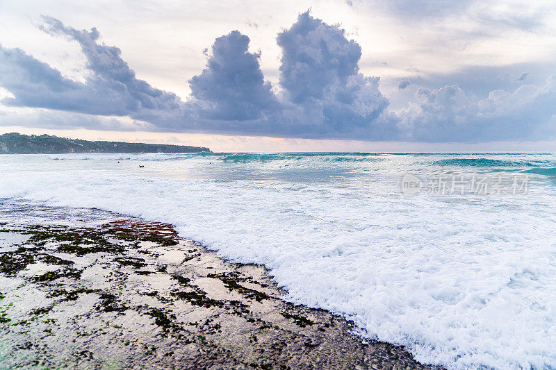 日落在海洋-蓝绿色的风暴海浪对多云的天空背景。