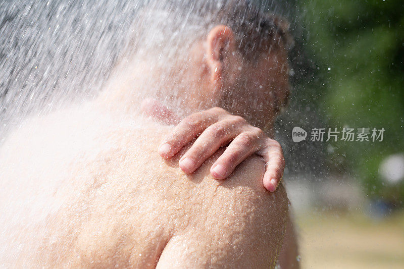 特写:一个夏天在户外洗澡的男人的肩膀