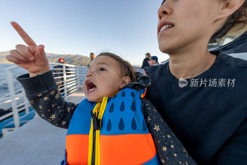 妈妈和蹒跚学步的女儿在船上享受观鲸之旅