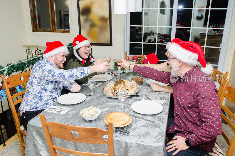 圣诞家庭围坐在餐桌旁敬酒