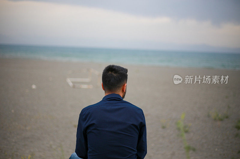 不快乐的人独自一人，望着远方的大海或海景地平线。