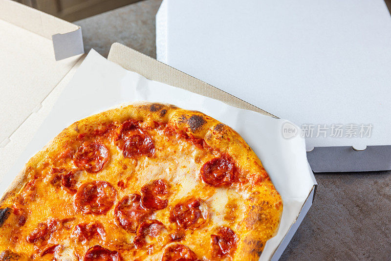 在打开的披萨盒子里烤意大利辣香肠
