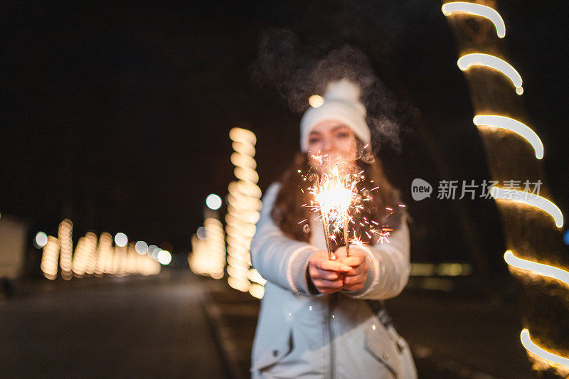 一名年轻女子手持烟花庆祝除夕的特写