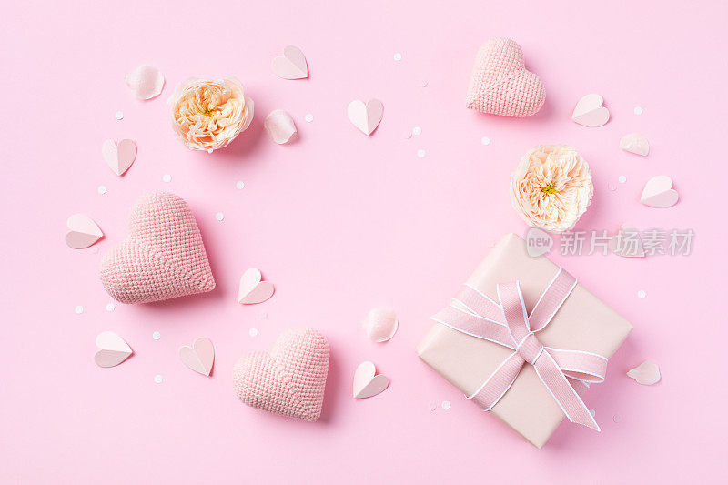 节日背景的生日，妇女或母亲节。粉红色的心，玫瑰花和礼盒在桌面视图。平的。