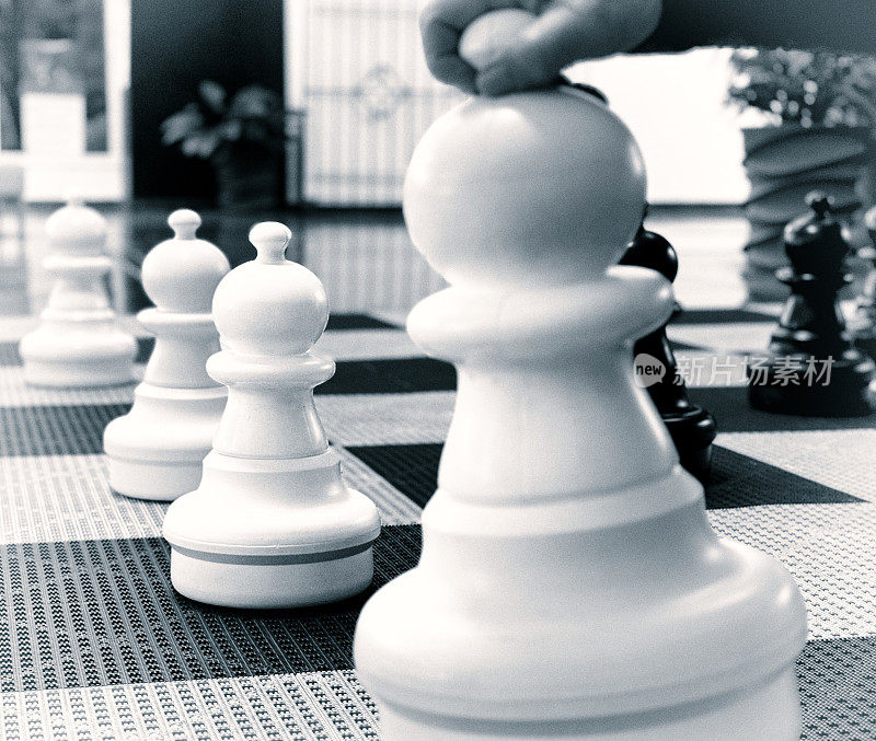 手移动大型户外棋子(卒)在国际象棋棋盘