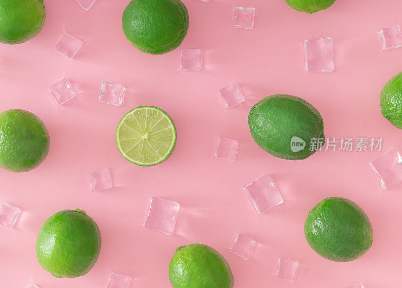 创意的夏季图案由绿色石灰和冰块在淡粉色的背景。水果最小的概念。时尚健康饮食模式背景理念。平躺，视野之巅。