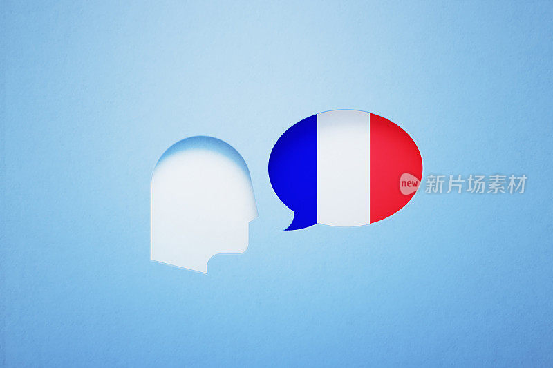 法语学习和说概念-语音气泡形状纹理与法国国旗坐在旁边的一个切割出的人的头在蓝色的背景