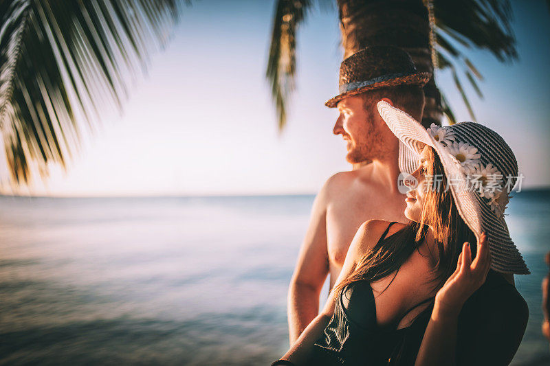 情侣们在海滩上放松，在热带岛屿上享受美丽的大海