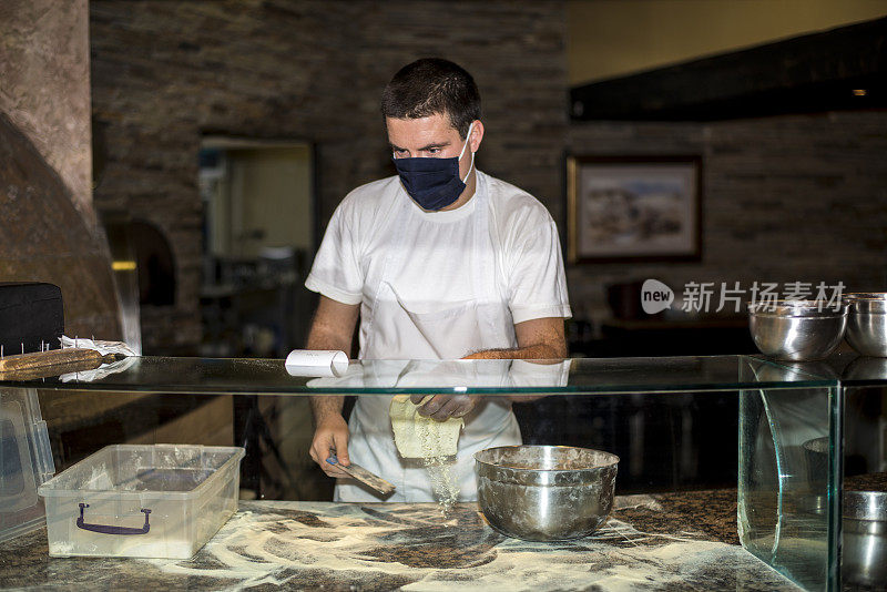 一个戴着防护面具在厨房工作的男人