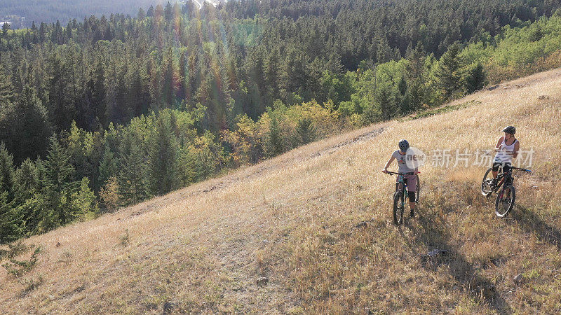 山地自行车手们在山谷和群山之上的开阔地带上停下来