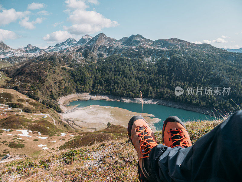 人的脚在山顶俯瞰高山湖泊