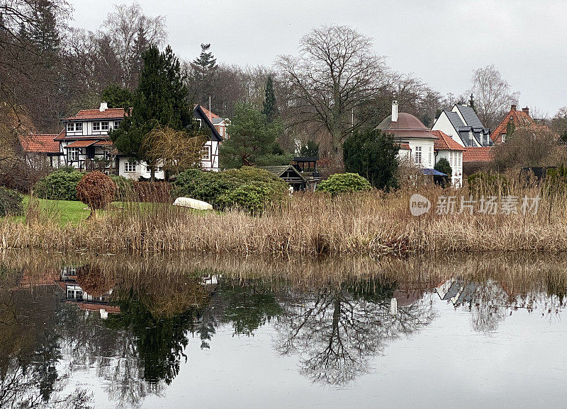 壮观的豪华别墅与湖景拍摄在寒冷的12月的一天在Virum，斯堪的纳维亚。