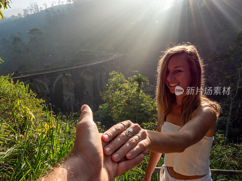 在斯里兰卡日出时，一对夫妇在桥附近牵着手