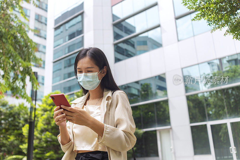 女商人戴着口罩在街上用手机