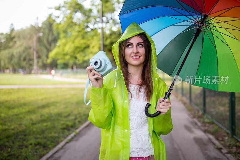 漂亮凉爽的女人带着五颜六色的雨伞在秋天的一天