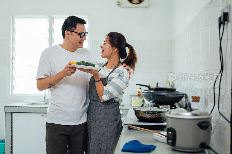 快乐的亚洲夫妇在厨房做饭