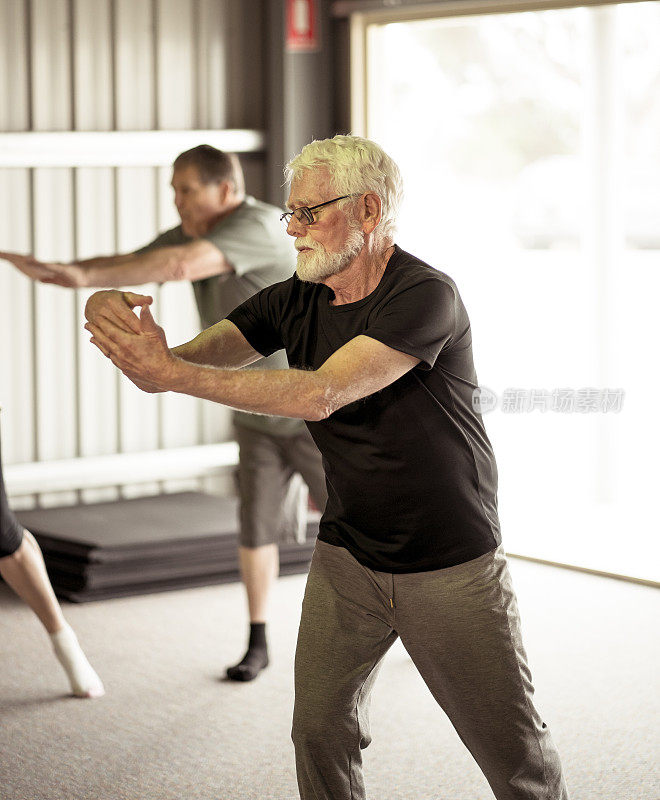 一群老年人在太极课上以积极的退休生活方式锻炼。锻炼对老年人的身心健康有好处。老年人保健和福利概念。