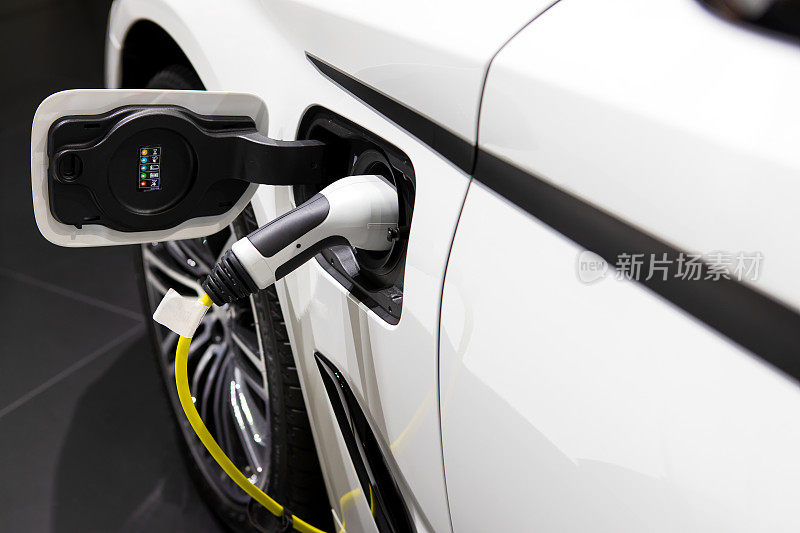 电动汽车或电动汽车的充电线插在电动汽车的一侧。环保可持续能源概念。