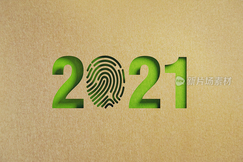 可持续发展的概念-剪出指纹形状的再生纸形成2021在绿色背景