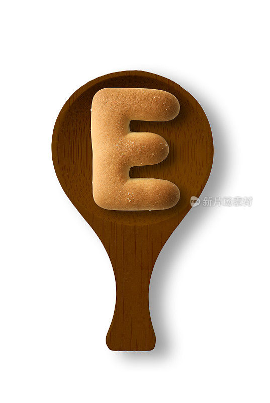 孤立的照片的大写字母饼干E上的木勺，在白色的背景