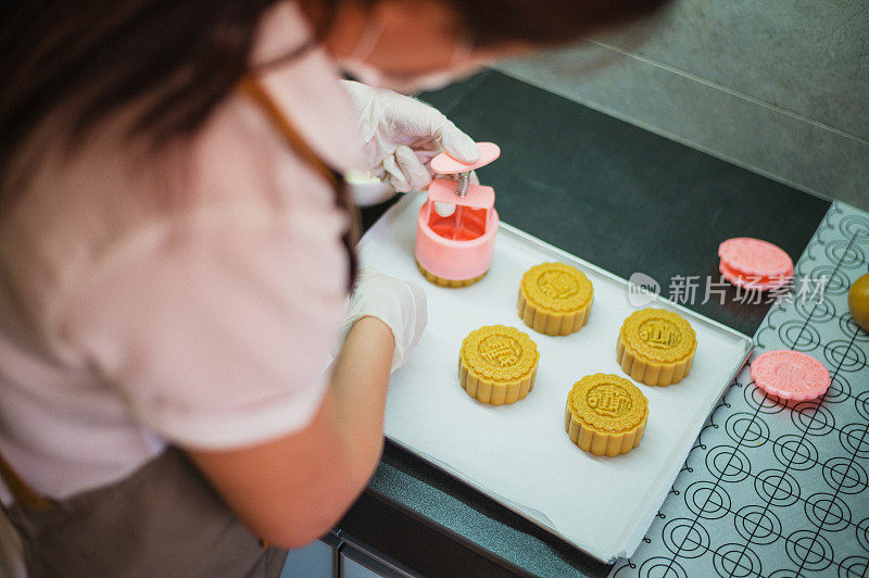 在烘烤前的烤盘上，女人们正在制作自制月饼糕点的面团