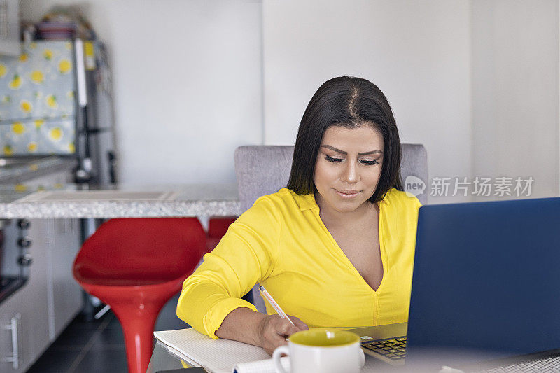 使用笔记本电脑在家工作的女性