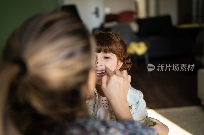 母女俩在家里玩着画脸游戏