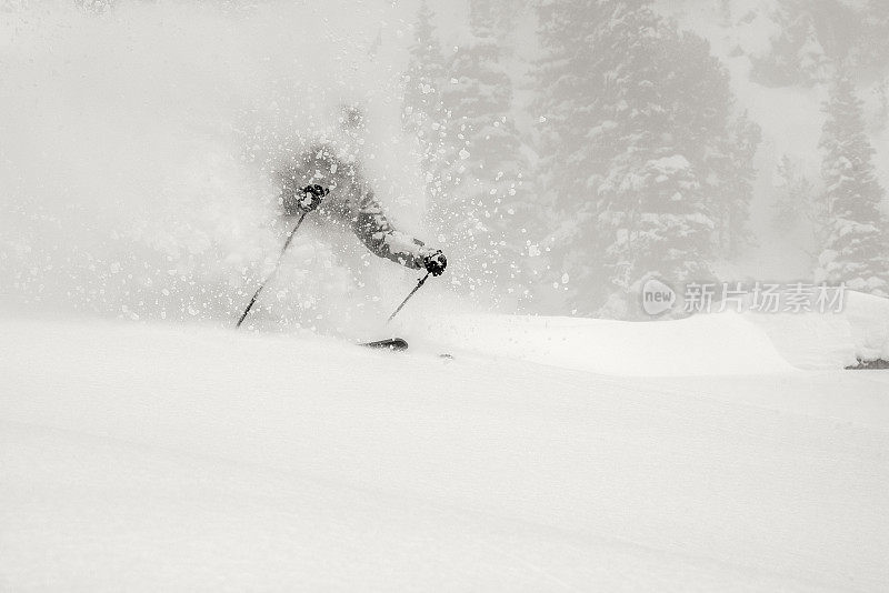 偏远地区的滑雪者穿过密集的粉末下降