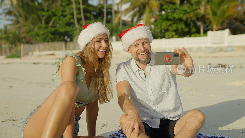 来自热带海滩的夏日圣诞问候。情侣们通过视频通话庆祝圣诞节