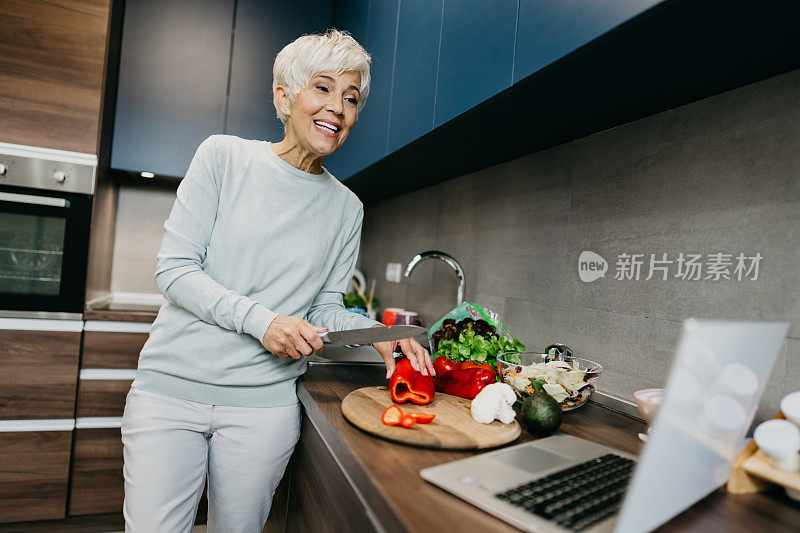 一位女士在厨房里用笔记本电脑打电话