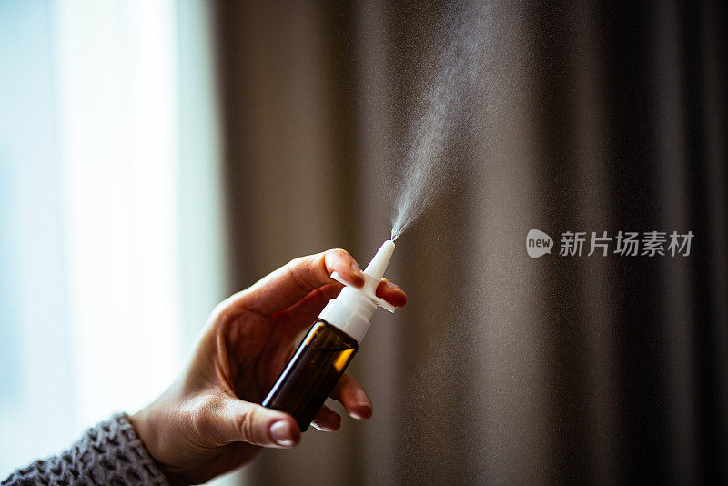 一名匿名妇女在家使用鼻腔喷雾剂
