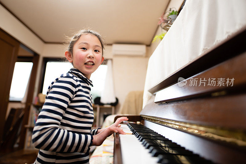 微笑的女孩在弹钢琴