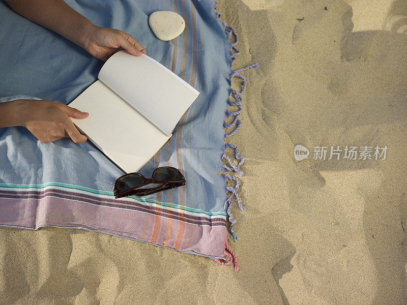 一个女人在沙滩上看书