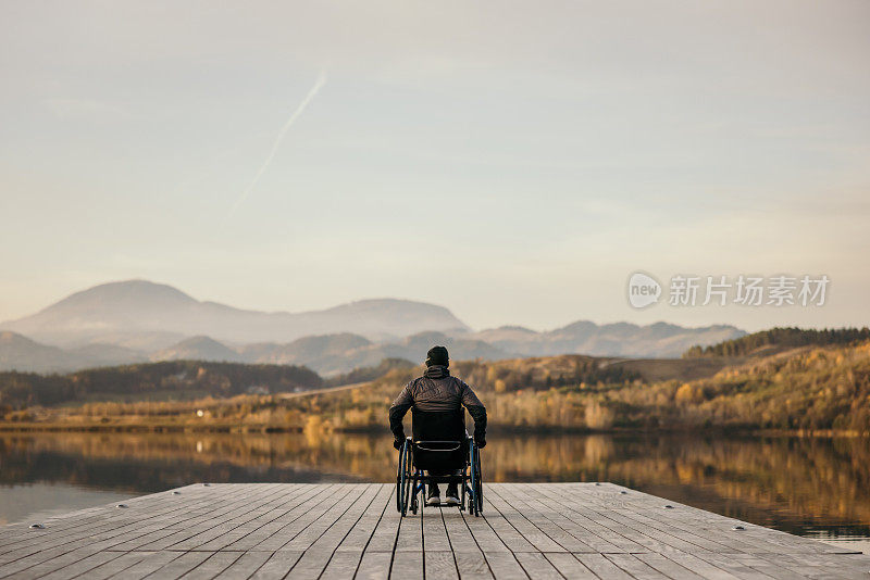 坐轮椅的残疾人在湖边欣赏大自然