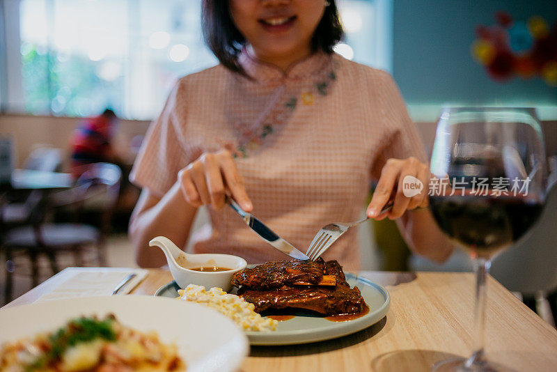 年轻女子在餐厅吃烧烤排骨