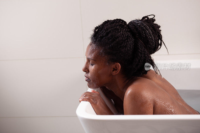 美丽的埃塞俄比亚女人与爆炸头享受洗澡。