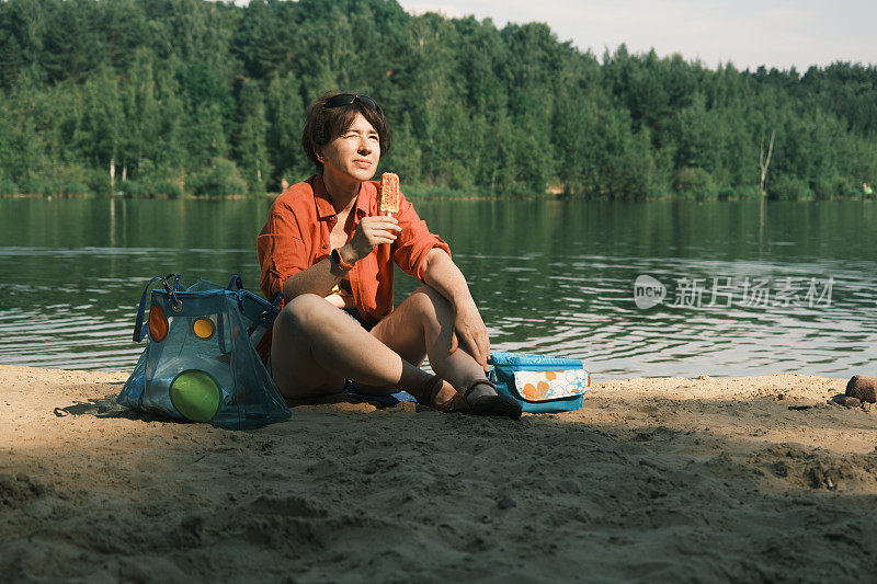一个女人在湖边吃冰淇淋