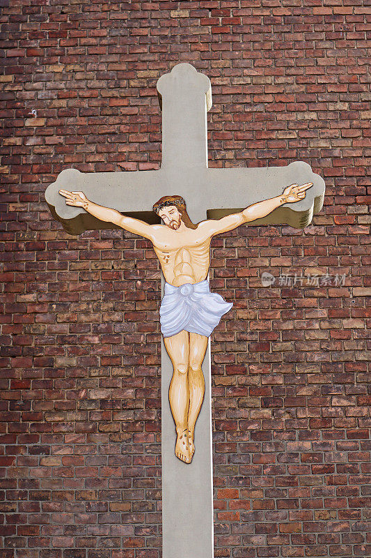 教堂砖墙前十字架上的耶稣基督形象