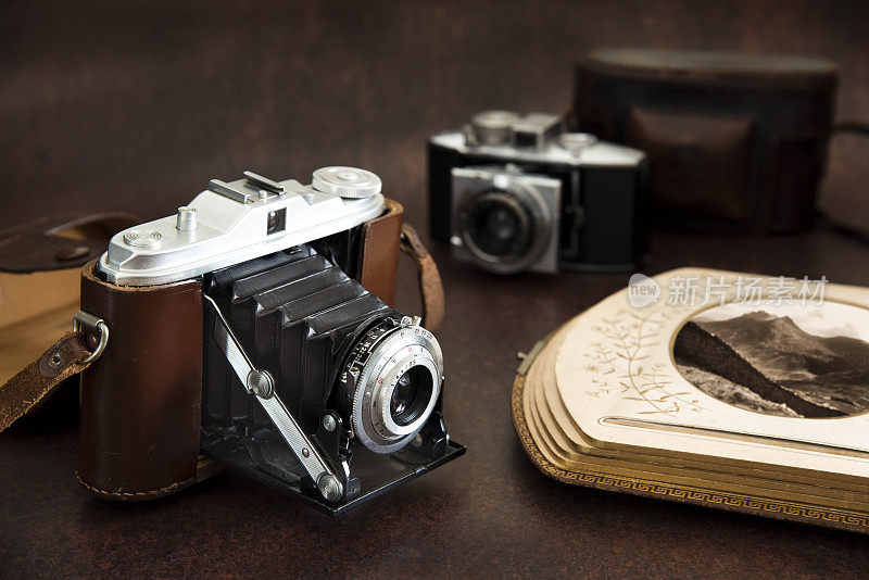 古董折叠风箱相机皮革表带和皮革古董相册-库存照片