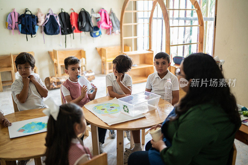 老师在学校的教室里和学生谈论回收